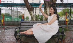 Mature and intellectual female music teacher Wei Wei wears a long skirt and shows her beautiful feet contentedly on the campus bench
