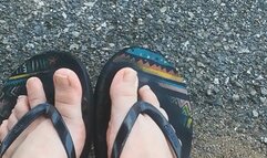 Sitting on a bench, I play with my feet in flip flops
