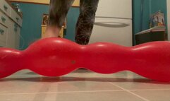 Stepping on and crushing long balloon until it deflates