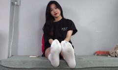 Sporty girl takes off her socks to show off her slender feet