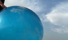 Riding on blue shosu ball on sea beach