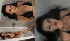 Jade lies in the filling bathtub and goes under the water