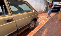 Kaena in jeans and flip flops tries to start the fiat 147