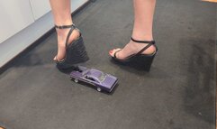 Giantess Raven Lee crushes a 1970 Plymouth GTX toy car in sexy black wedges with painted toenails high right view