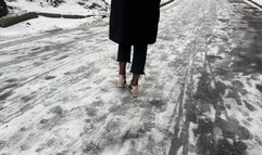 A girl in high heels wants to get to the road, but her path lies over a slippery hill