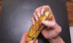 Long sharp natural nails destroying banana