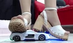 crushing a police toy car robot with nylons and hard soled wooden sandals