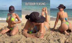 Teasing on the beach in micro bikini on the sand