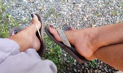 2 women let their sandals dangle while tapping them with the tips of their toes (1)