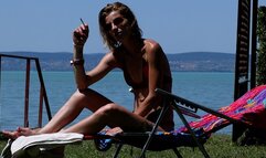 Eve sensually smoking 120's by the lake while sunbathing in slow motion 3