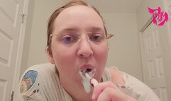 Brushing teeth and scrubbing tongue wearing glasses and torn shirt