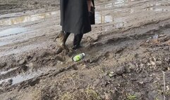 A girl in high-heeled leather boots walks through mud and then falls into it with her knees (short version)