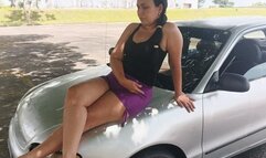 Woman crossing her legs while sitting in the front of her car like a model (3)