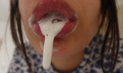An Indian girl brushes her teeth and a lot of white fluid comes out of her mouth then she plays with her tongue and teeth