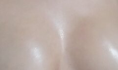 sensual woman massages her breasts with oil