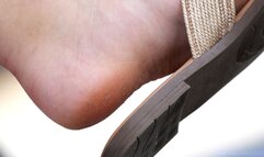 Dirty feet slippers dangling, foot fetish admiration, feet and shoes close-up.