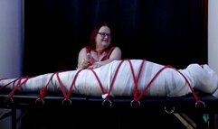 Miss M torments a helpless mummified man for Halloween
