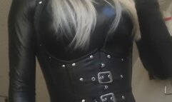 Smoking in tight leather corset and catsuit
