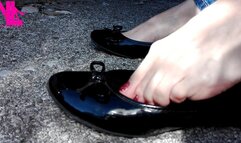 Tiptoe and shoeplay in black flats and red nailpolish outside my car
