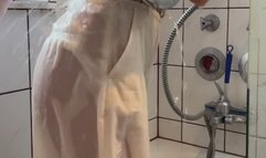 White longsleve, with beige pants in shower and bathtub