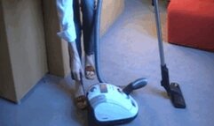 Madame Caren vacuuming carpet in clogs with white vacuum cleaner