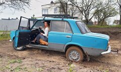 Chloe is stuck in a blue VAZ and spinning the wheels