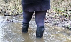 Black rubber boots and a deep stream