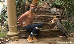 Bare chested blue eyed blonde sits bound in the great outdoors! 4k Version