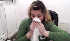 Sneezing into hanky in green hoodie