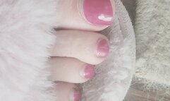 Pink fuzzy slippers and pink-red toes