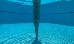 Wrist self-bondage in the resort pool in a rainbow bikini
