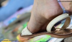 Public sandals dangling dirty feet close-up