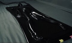 Orgasms in a black latex bed with a pear gag