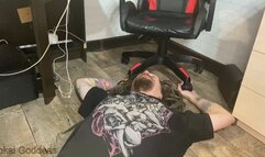 Human footstool with his hands under chair wheels and hands trampling in high heels