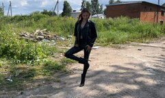 girl in leather boots with high heels walks through the mud