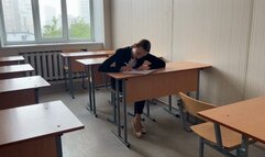 a girl sits at lesson in school and plays with her feet and ballet shoes
