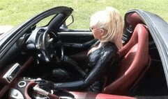 Hot blonde slut in black latex catsuit drives super sport car outdoor