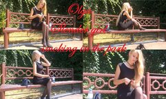 Slender girl Olga smokes in the park