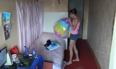 Svetlana is in a hurry to inflate a beach ball