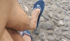 Shoeplay on a public bench with flip flop and dried out feet