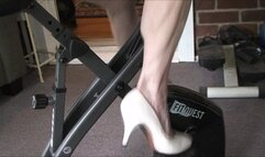 Lilly on the stationary bike, panning up to her biceps and back