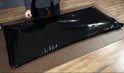 Rope bondage with pear gag in a black latex bed