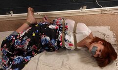 Tapegagged barefoot redhead Kathy in long flower dress, hogtied with her big toes tied, is getting her feet oiled and tickled (HD WMV)