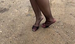 girl in nylon stockings walks through the mud and slides on the mountain, causing her stockings to tear