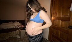 a pregnant woman anoints her tummy with oil from stretch marks