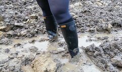 Muddy ground and black rubber boots