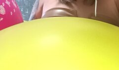 girl poping small foil disney balloons with needle