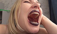 A BIG MOUTH WITH PURPLE LIPS YAWNS!