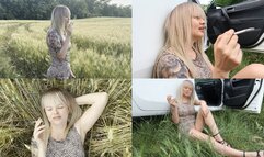 Blonde relaxes in nature and smokes 2 cigarettes